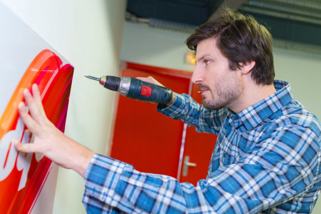 man drilling the wall with drill perforator