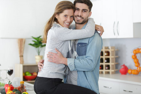 young happy couple hugging in kitchen in the morning