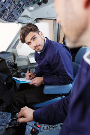 attentive aviation student listening to teahcer in cockpitの写真素材