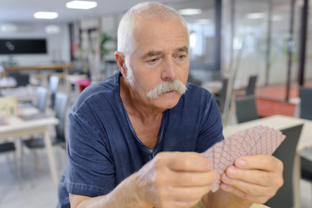 portrait of a man playing cards alone