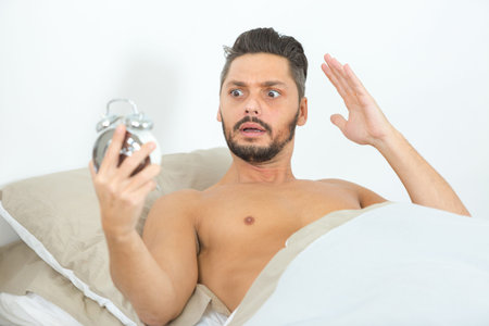 man looking scare looking at the alarm