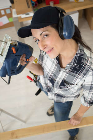 a woman is cutting woodの写真素材