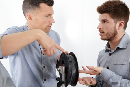 two workers with electricity cables indoors