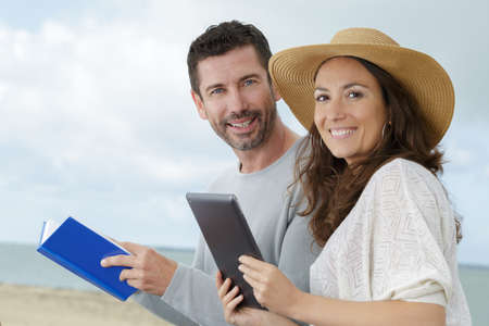 loving couple using a tablet on the beachの写真素材