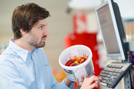 portrait of hardware store worker checking paint in computerの写真素材