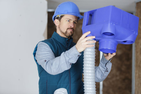 a plumber checking ceiling pipes