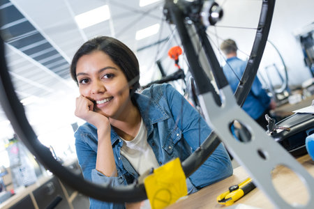 portrait of young lady seen through spokes of bicycle wheel