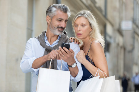 mature couple using mobile phone in the cityの写真素材