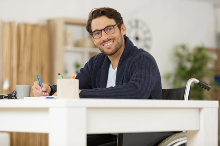 happy businessman in wheelchair using laptop