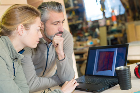 warehouse workes looking at laptop in warehouse