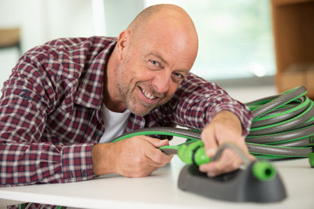 man connecting a garden hose