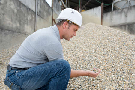 male worker checking the quality of the peebles inf factoryの写真素材