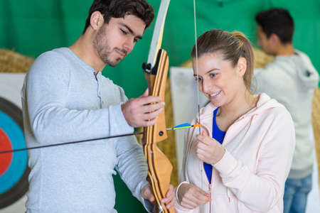 young woman smiling holding archer bowの写真素材