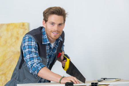 portrait of carpenter working with a saw at construction siteの写真素材