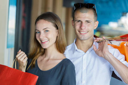 happy young couple walking in the city after shoppingの写真素材