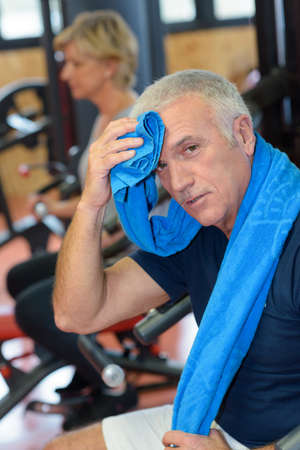 senior man wiping the sweat with a towelの写真素材