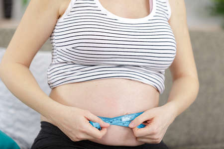 a pregnant woman measuring bellyの写真素材