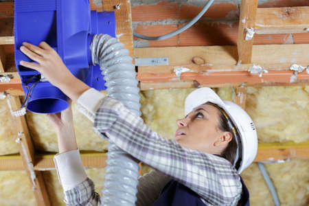 a woman during inspection the ventilation pipesの写真素材