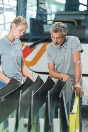 mechanic choosing correct repair panel for bus