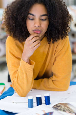 beautiful woman choosing thread in workshopの写真素材