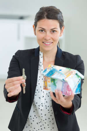 businesswoman holding keys to house models housing conceptの写真素材