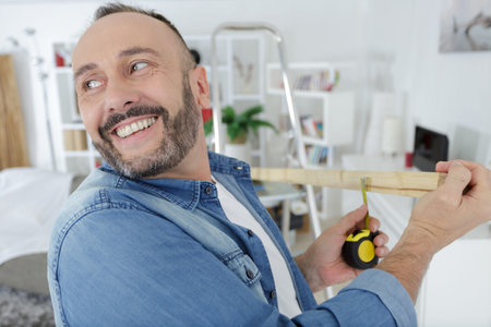 handyman laughing as he works with wood