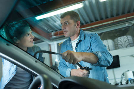 automotive glazier removing rubber seal from windscreenの写真素材