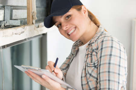 happy young female builder with a clipboardの写真素材