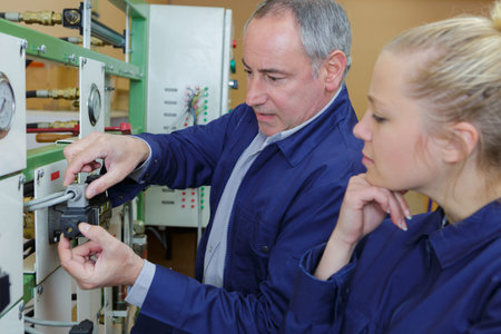 female student observing teacher using a machine