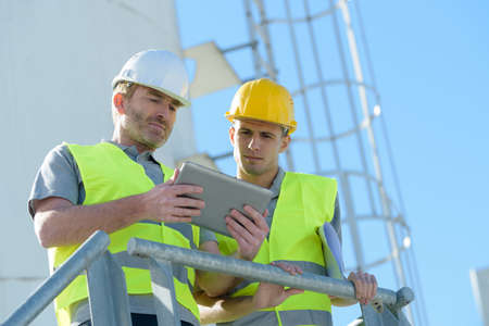 workers in charge of silo looking at tabletの写真素材