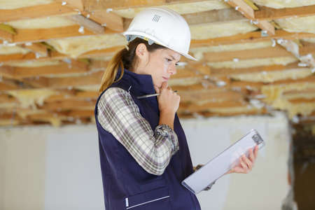 female worker holding paper plans and clipboardの写真素材