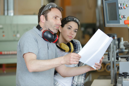 man and woman reading paperwork before using machine
