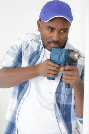 man is drilling a wall