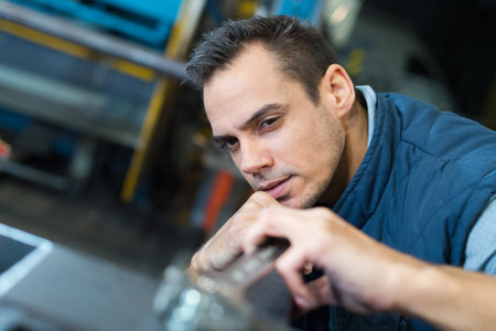young mechanic working on a car engine