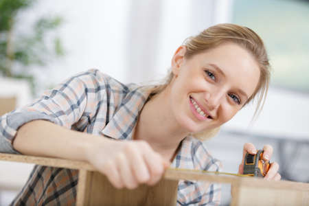 woman measuring a piece of woodの写真素材