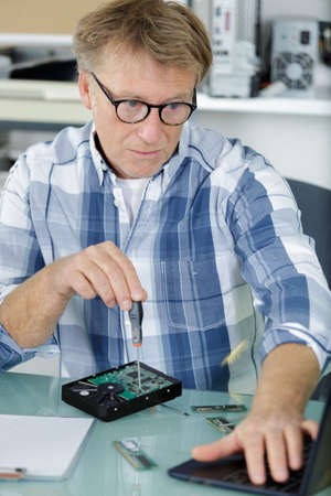 man turns off the screw on the hard driveの写真素材