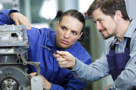 awo mechanics - man and woman examining car engine