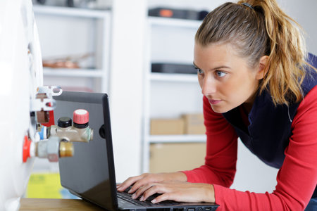 portrait of female plumber working on computer