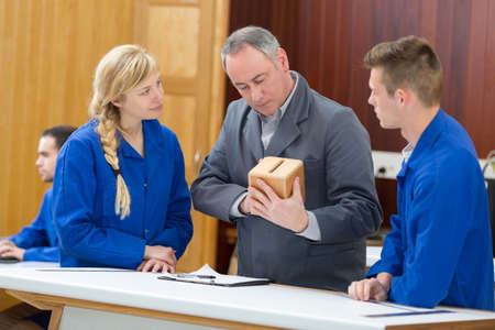 carpentry tutor inspecting box students have madeの写真素材