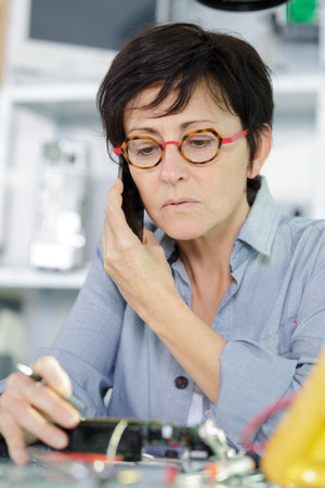 female computer technician is consulting a users by the phoneの写真素材