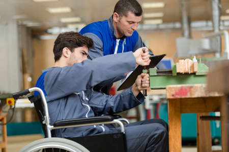 disabled worker in wheelchair in factoryの写真素材