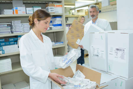 two pharmacists preparing medicine container in a pharmacyの写真素材