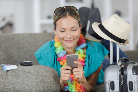 woman with suitcase sitting on sofa