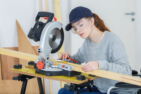 young latin female carpenter measuring and marking wood