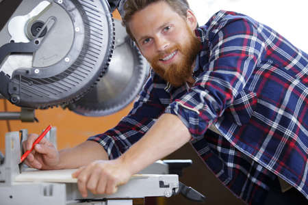 efficient man operating circular saw in wood workshopの写真素材
