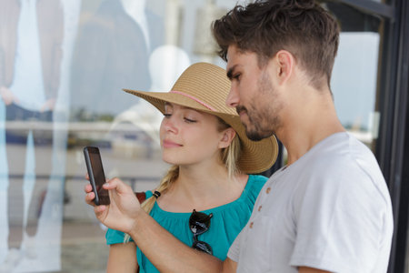 woman and man taking picture of window