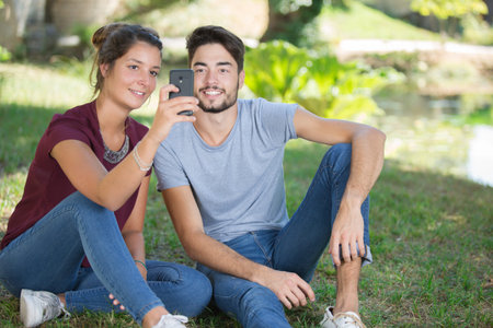 young couple taking selfie in the park