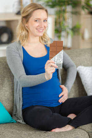 pregnant woman eating black chocolateの写真素材