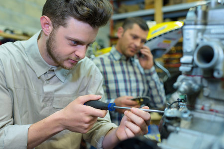 worker twists the screw with a screwdriver