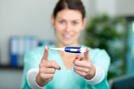 woman holding a digital thermometer